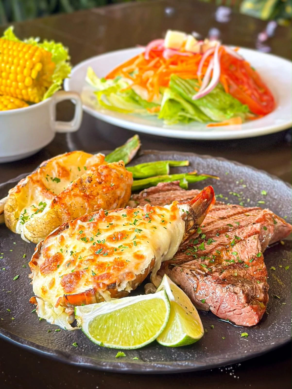 Carne a la parrilla y mariscos servidos con acompañamientos en Entre Brasas